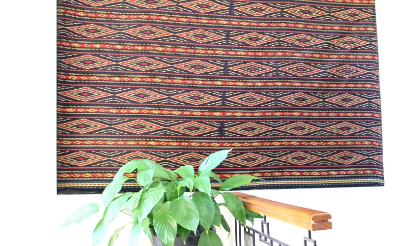 Handwoven Toraja textile with red and gold geometric motifs from the Sa'dan weaving tradition