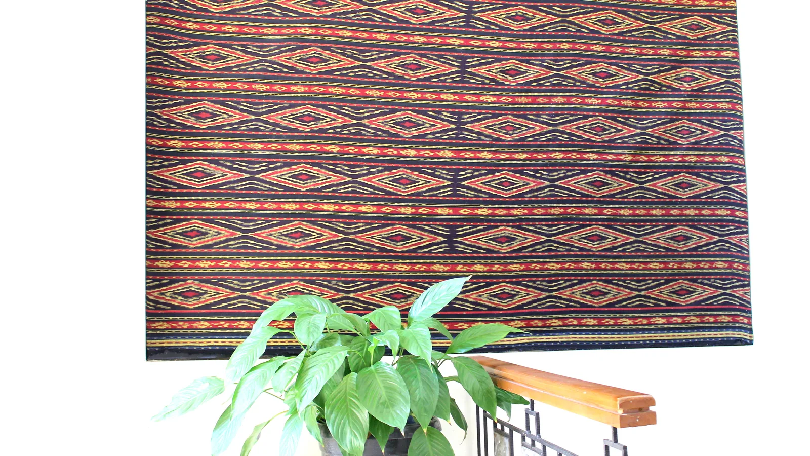 Handwoven Toraja textile with red and gold geometric motifs from the Sa'dan weaving tradition