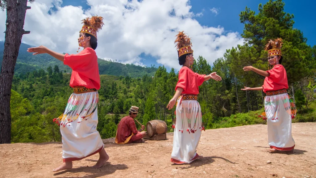 Dancers in traditional Toraja dress performing the pa'gellu dance on a highland ridge