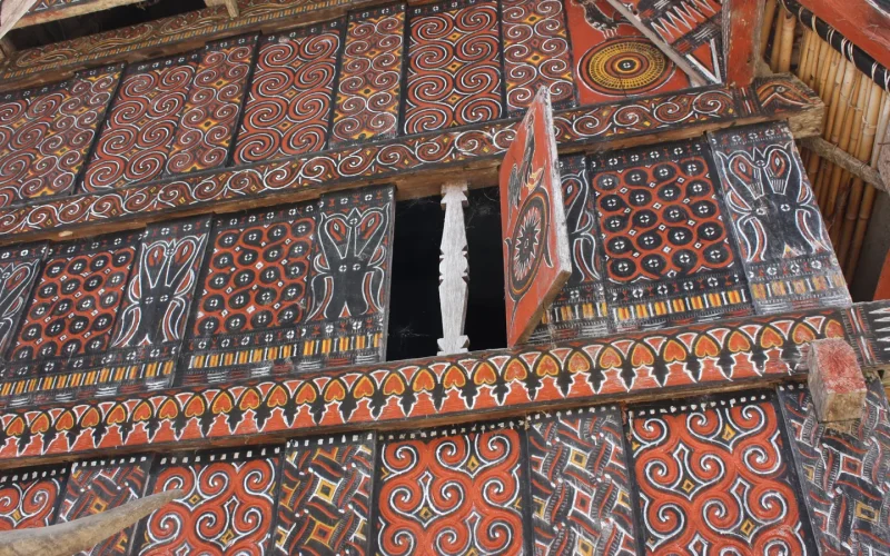 Carved and painted pa'ssura panels on a tongkonan facade at Palawa, the motifs used on Toraja crafts